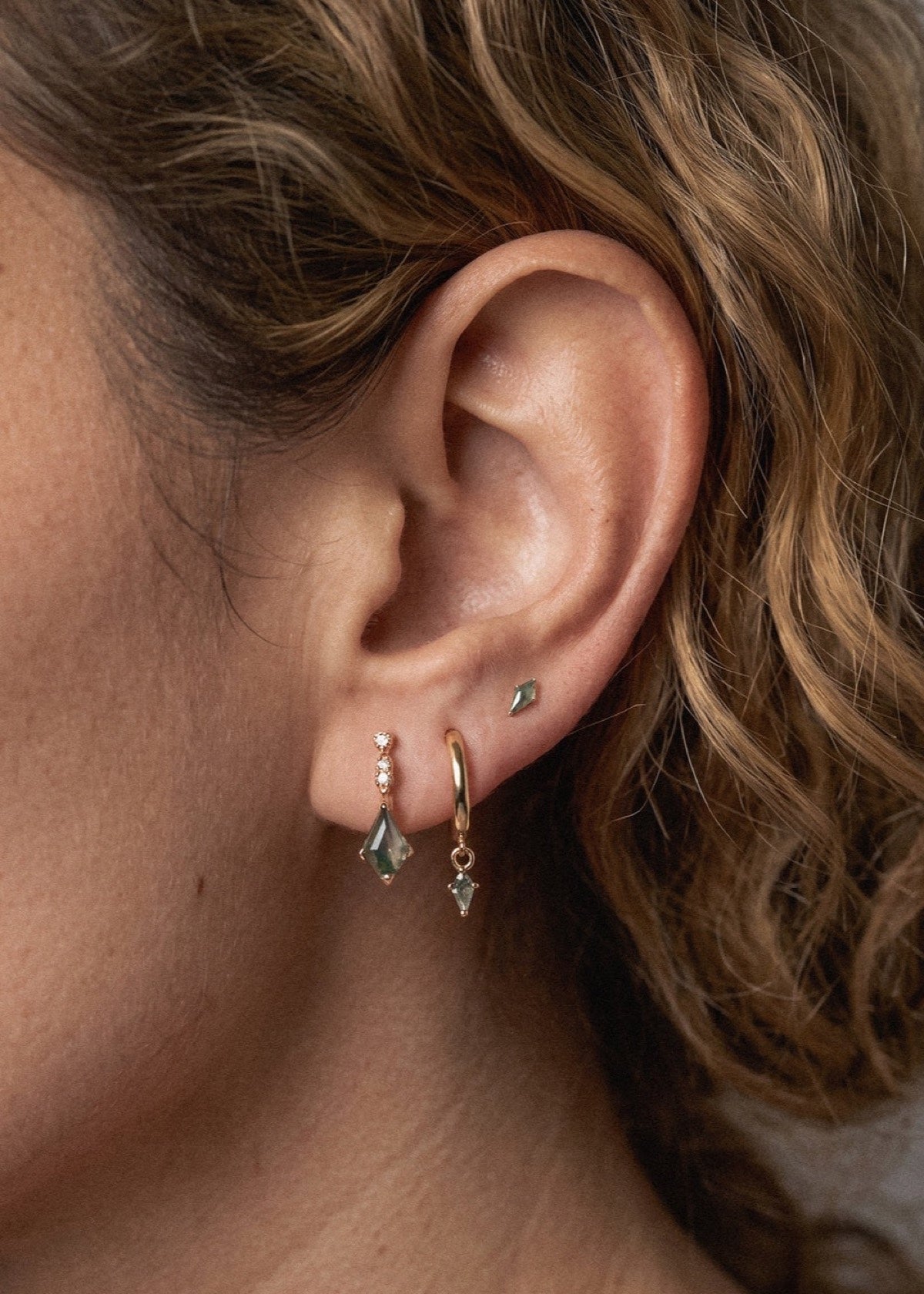 Close-up of a moss agate kite stud and matching gold hoop stack