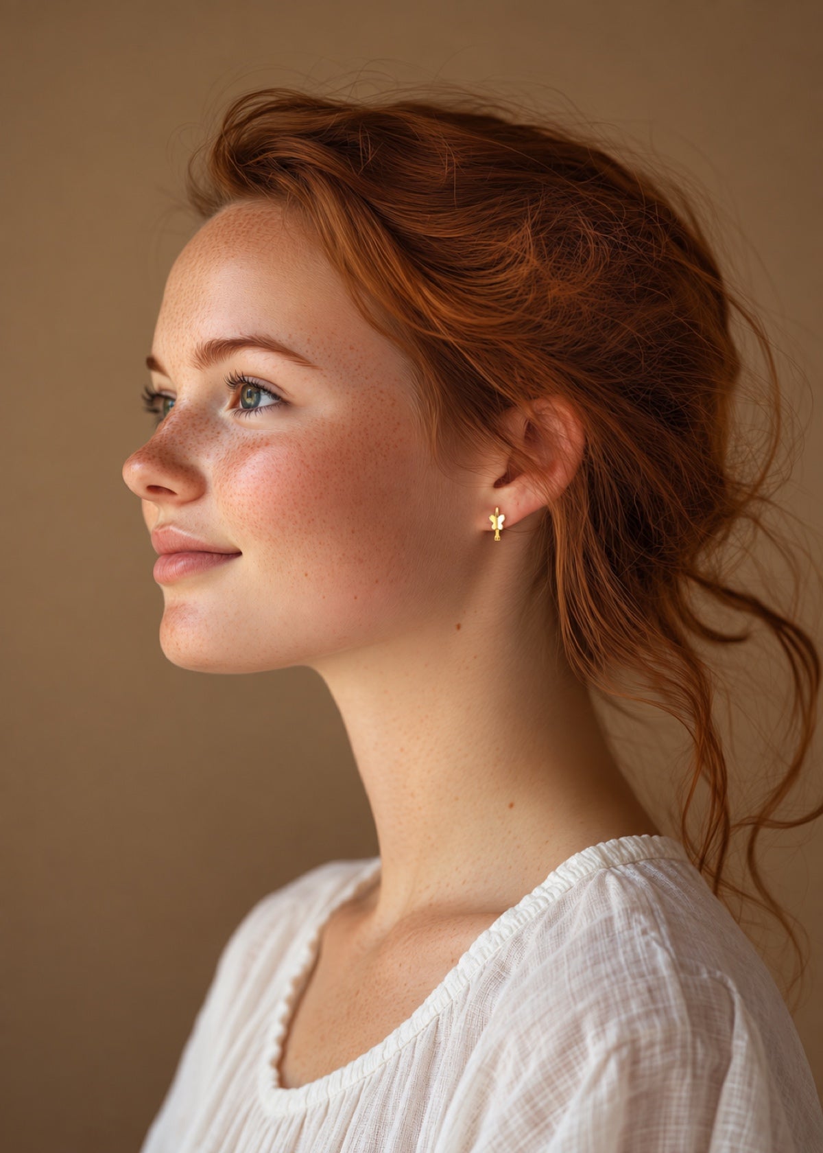 Butterfly Huggie earring worn outdoors with hair pulled back