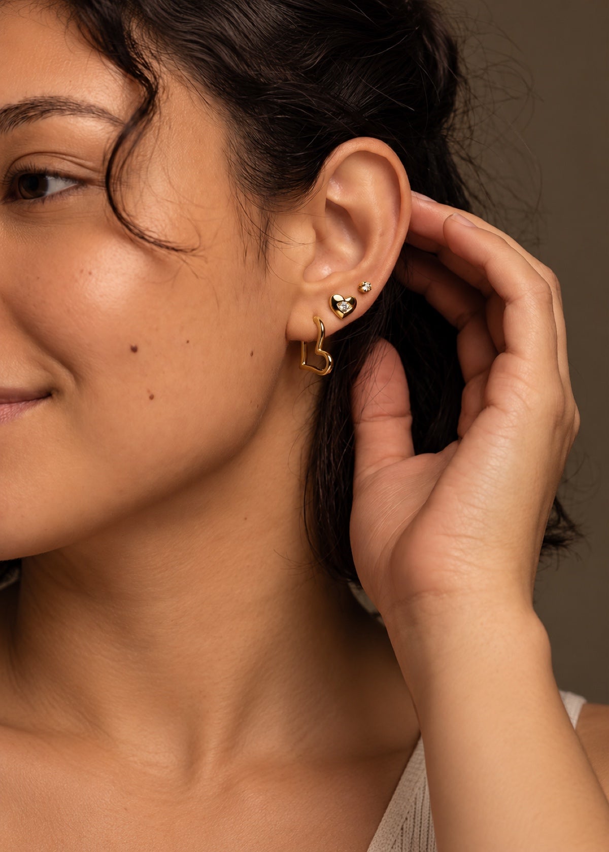Gold heart studs and huggies worn as an ear stack