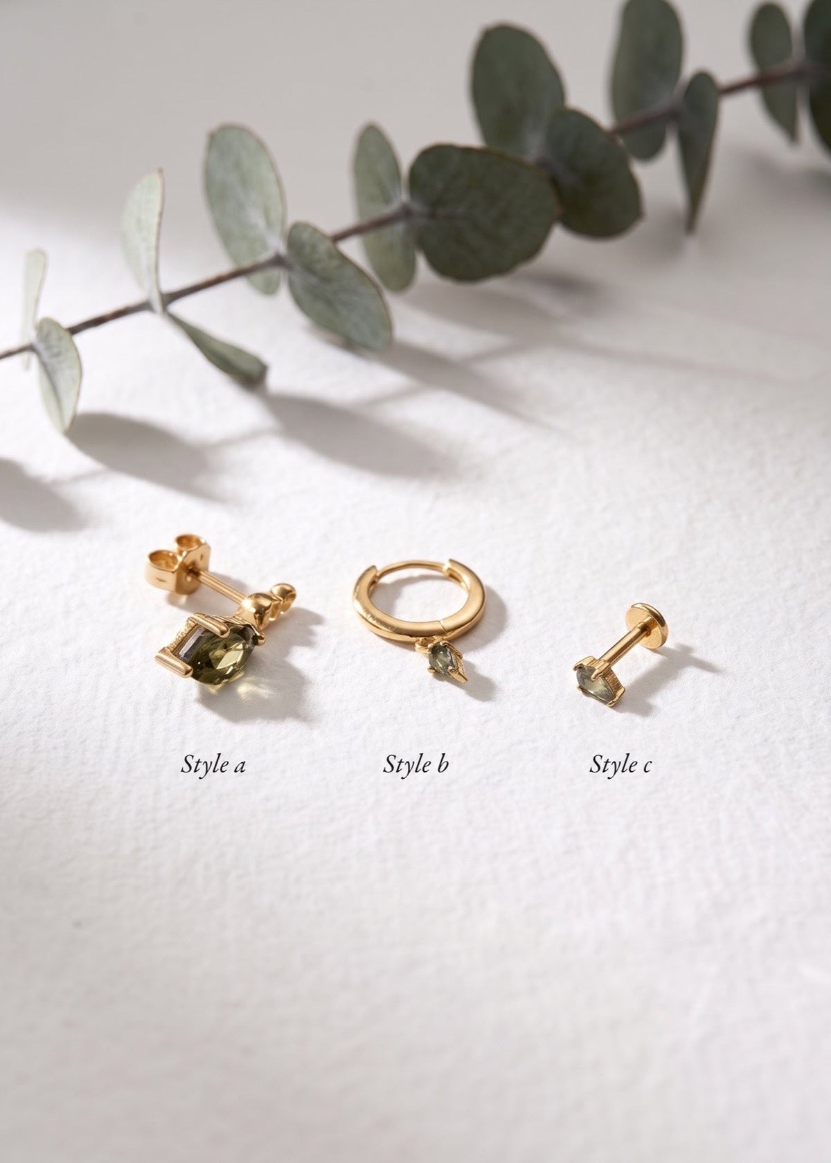 Moss agate earring styles A, B and C displayed beside eucalyptus