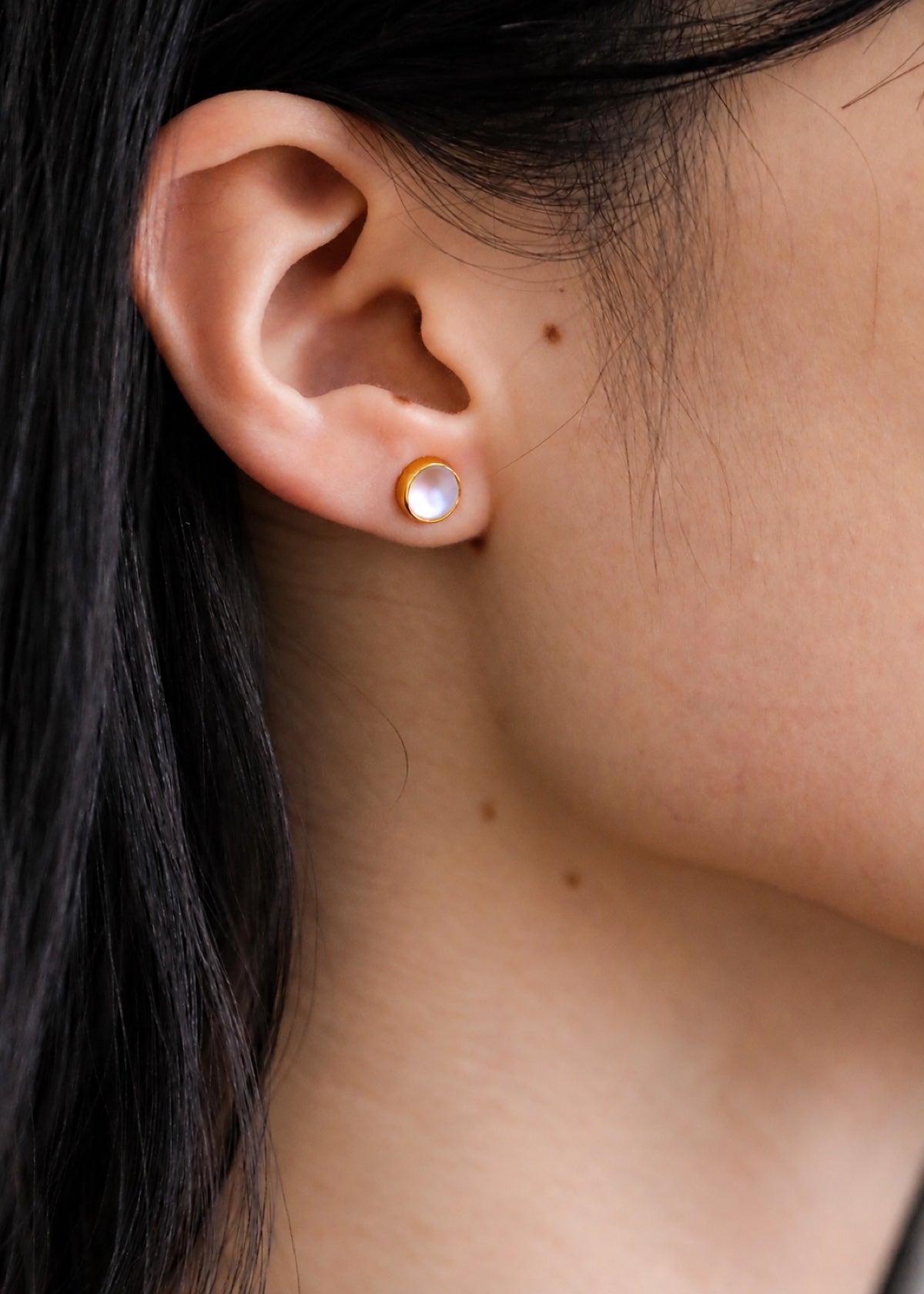 Round moonstone stud worn alone without its bar drop
