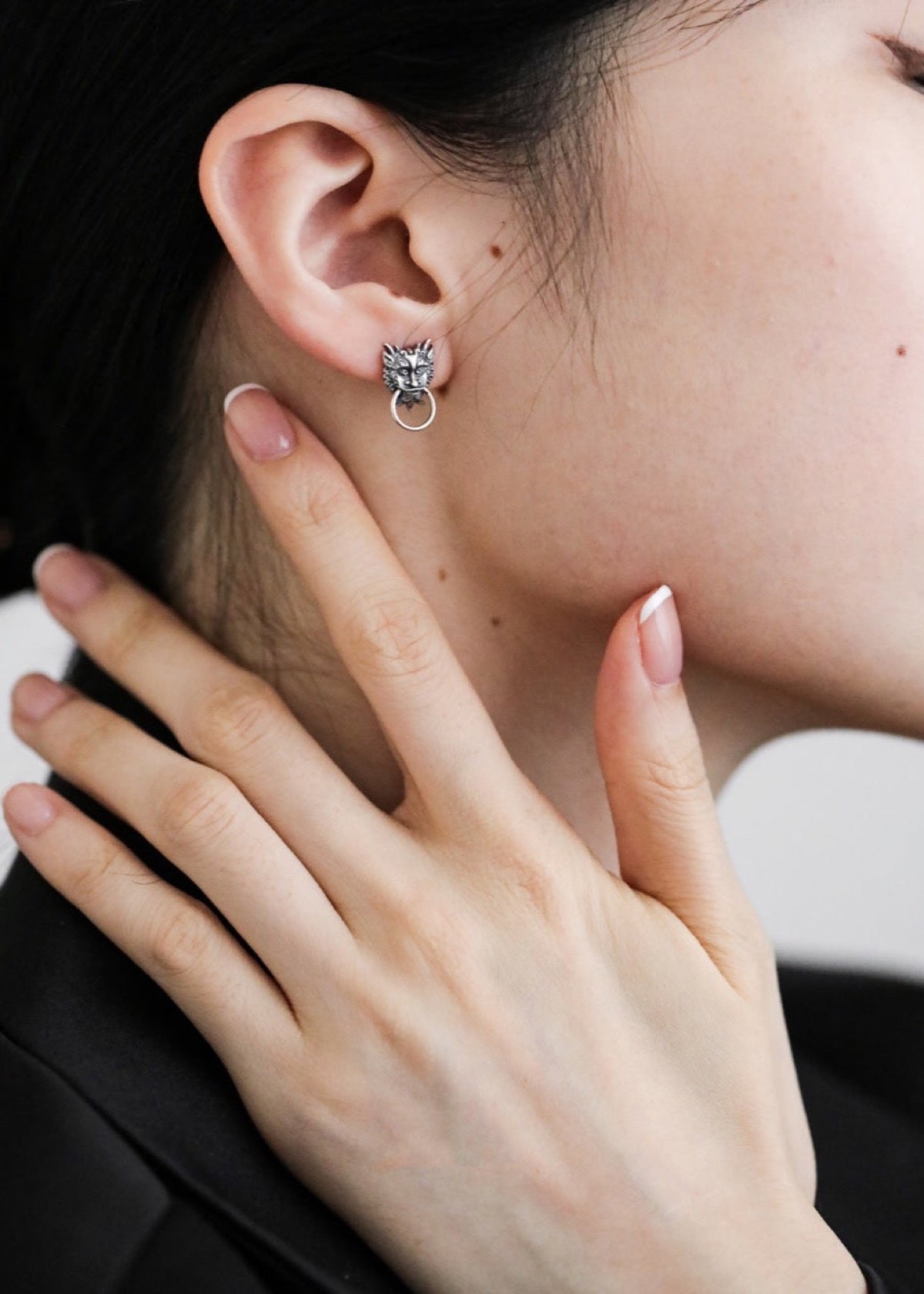 Chinese Dragon stud earring worn with a hand beside the face