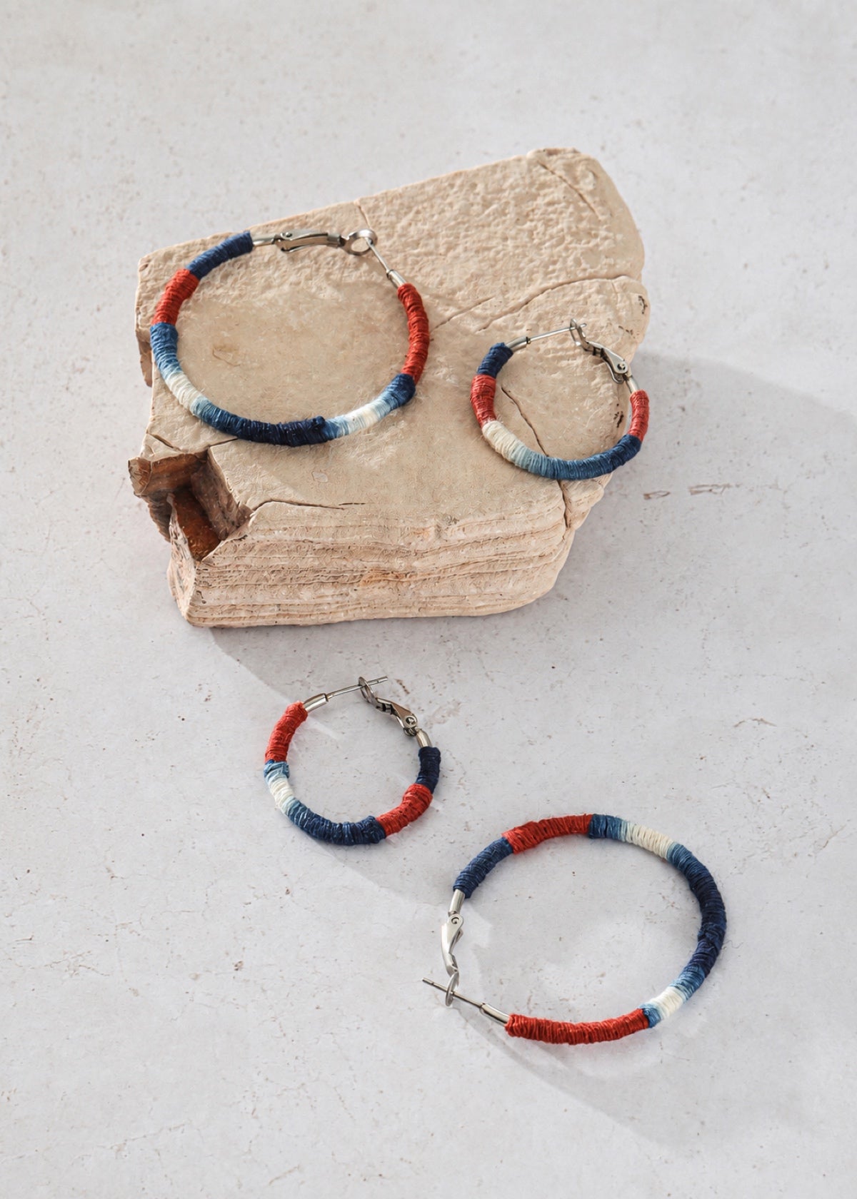 Small and large Shibori textile hoops arranged around a wooden block
