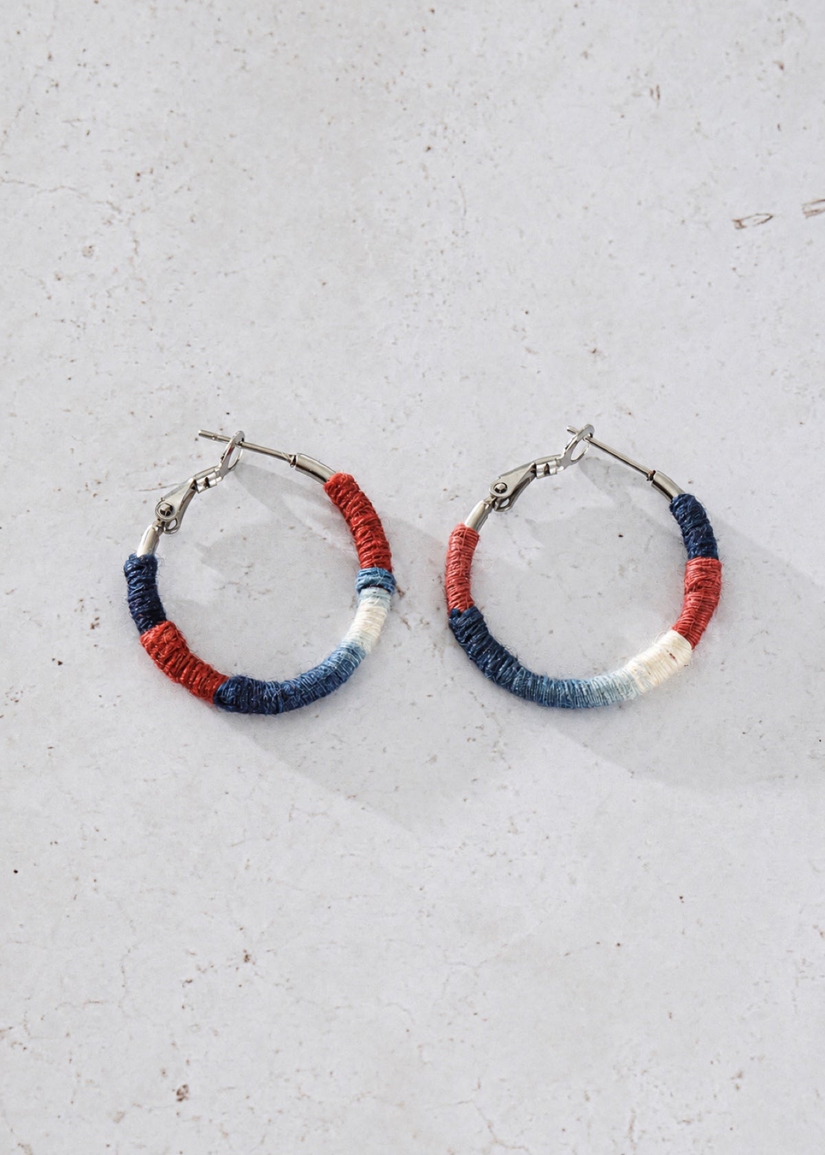 Pair of Shibori textile hoops showing thread wrapping and clasps