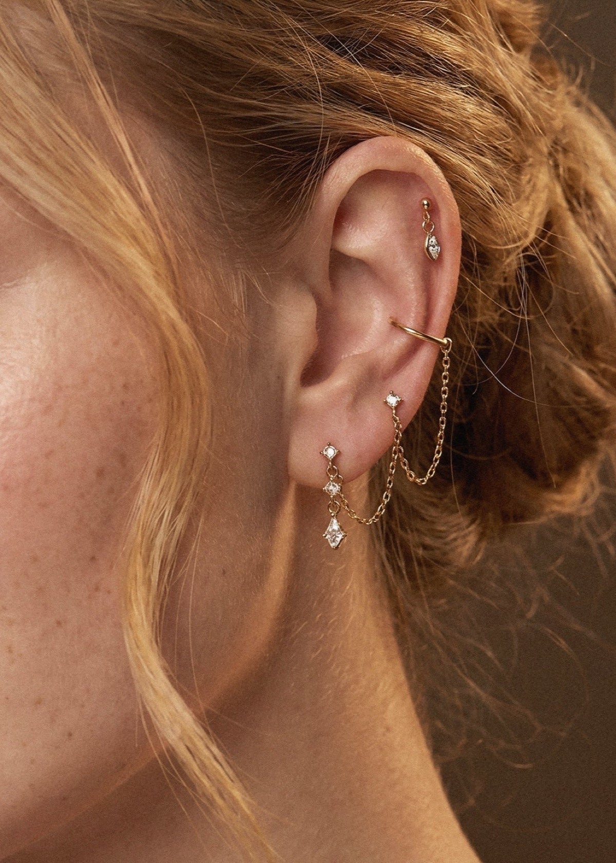 Close-up of a double-piercing chain earring showing its draped chain