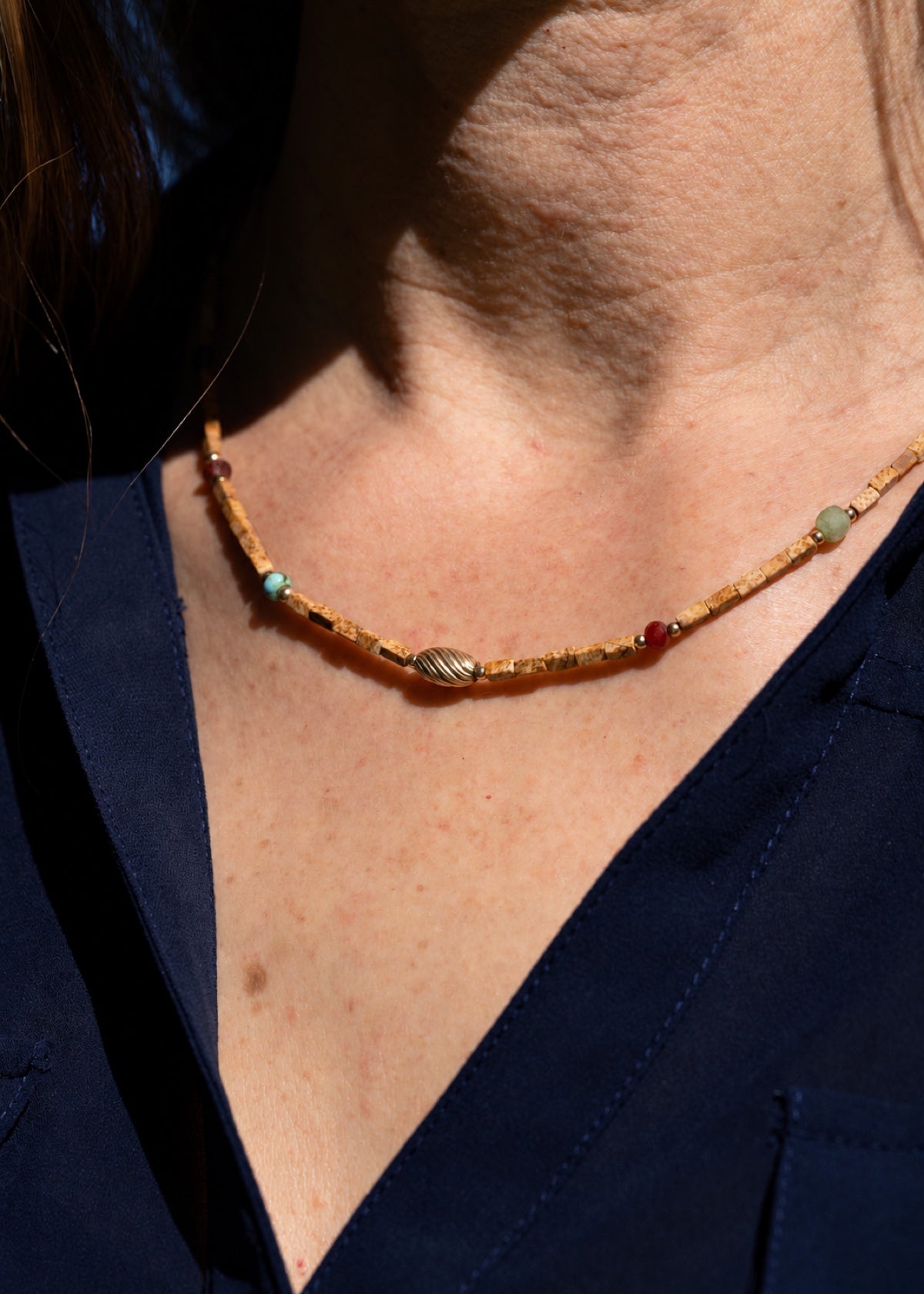 Close-up of a landscape jasper choker worn at the neckline