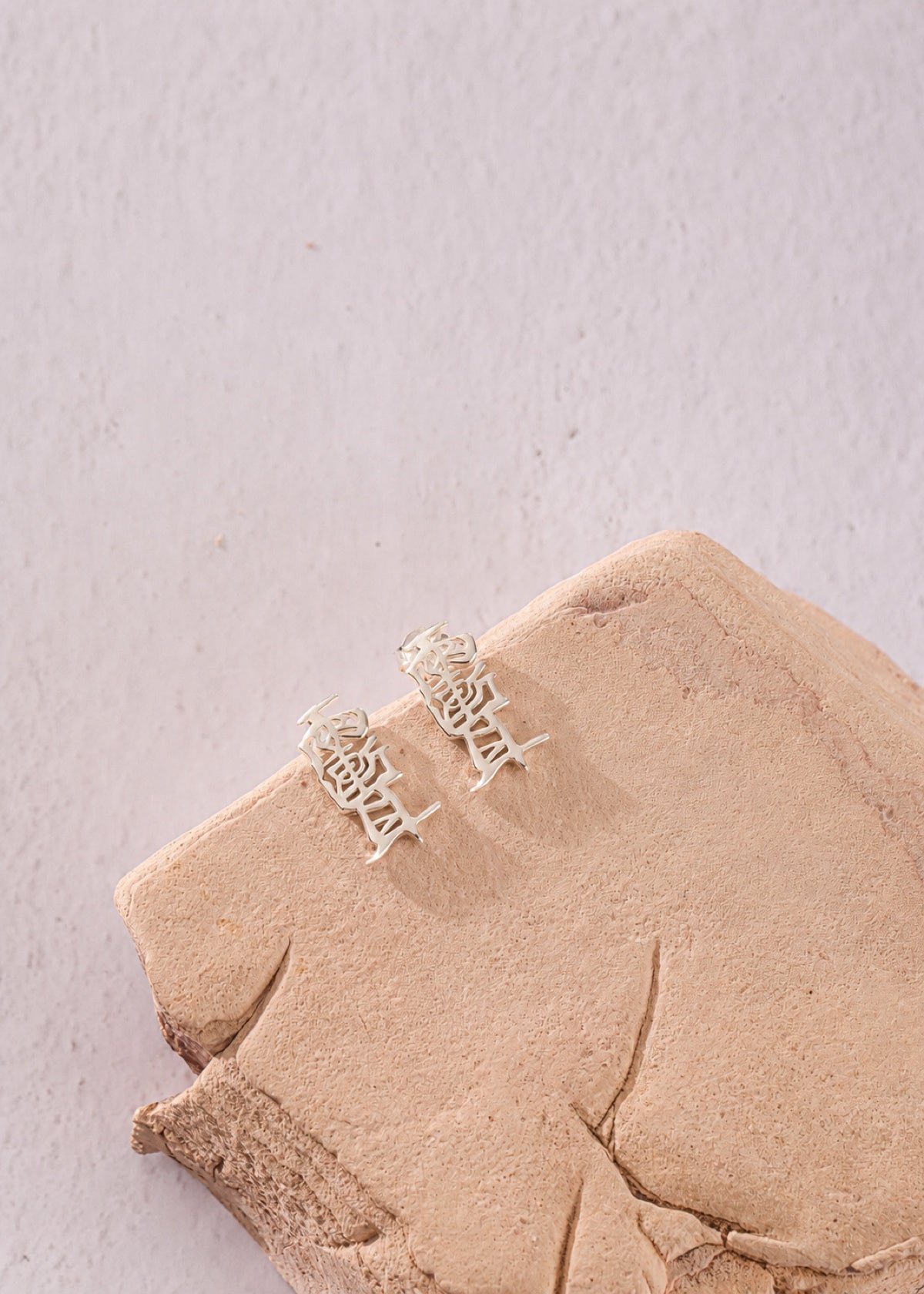 Taoist Amulet studs resting on a pale stone block