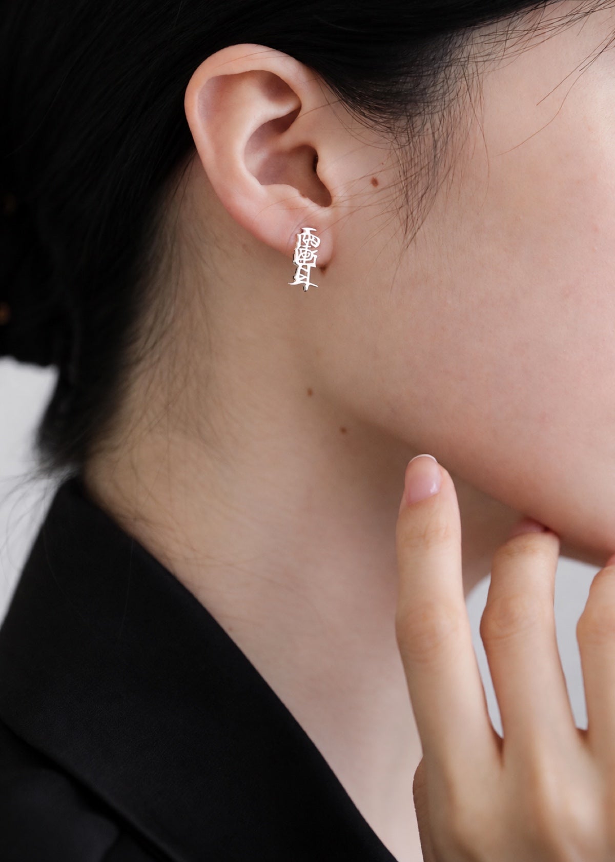 Taoist Amulet stud worn beside dark hair