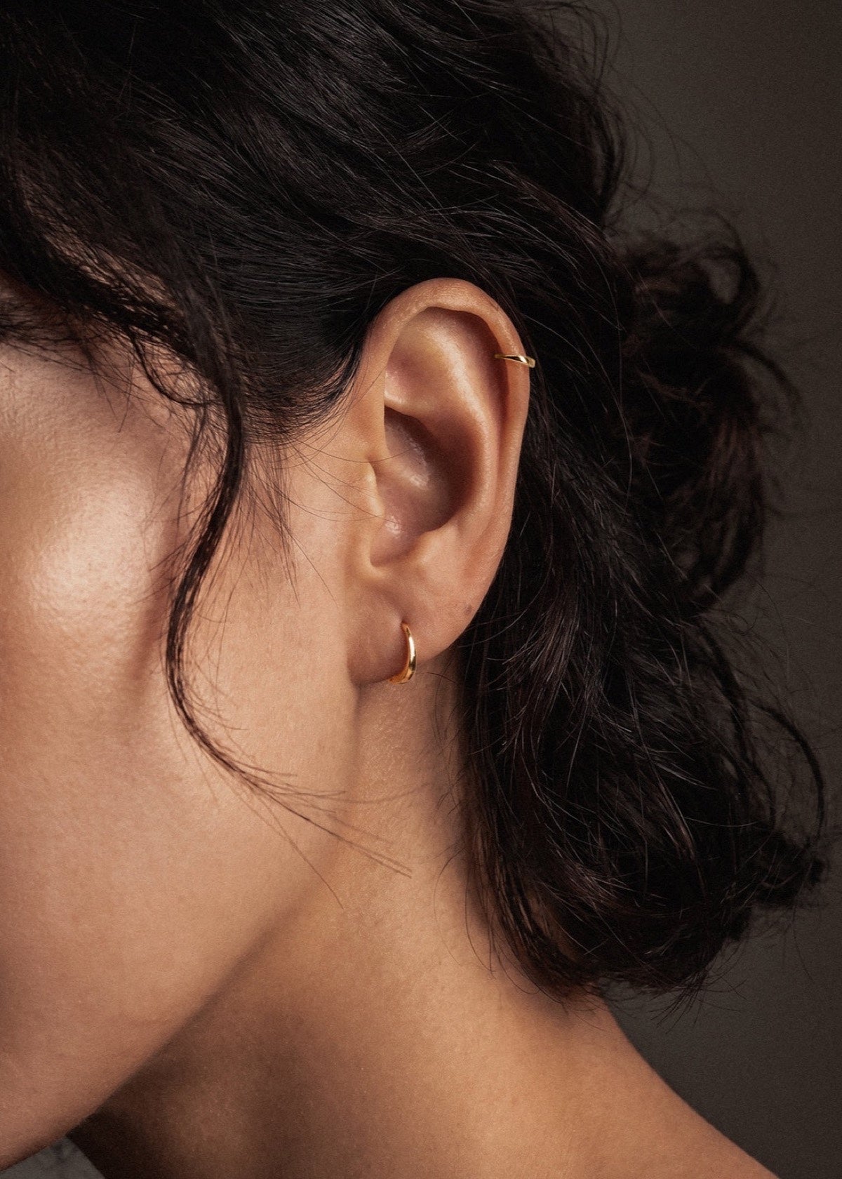 Small sterling silver D Shape sleeper earring worn in an earlobe